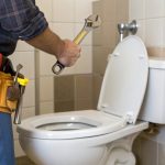 Plumber fixing a toilet.